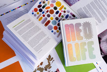 Load image into Gallery viewer, White book with metallic lettering—Neo.Life—leaning on an open spread of the book with a picture of pills.